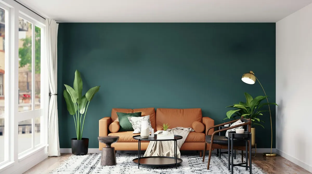Salon au mur vert sapin avec canapé en cuir et grandes fenêtres